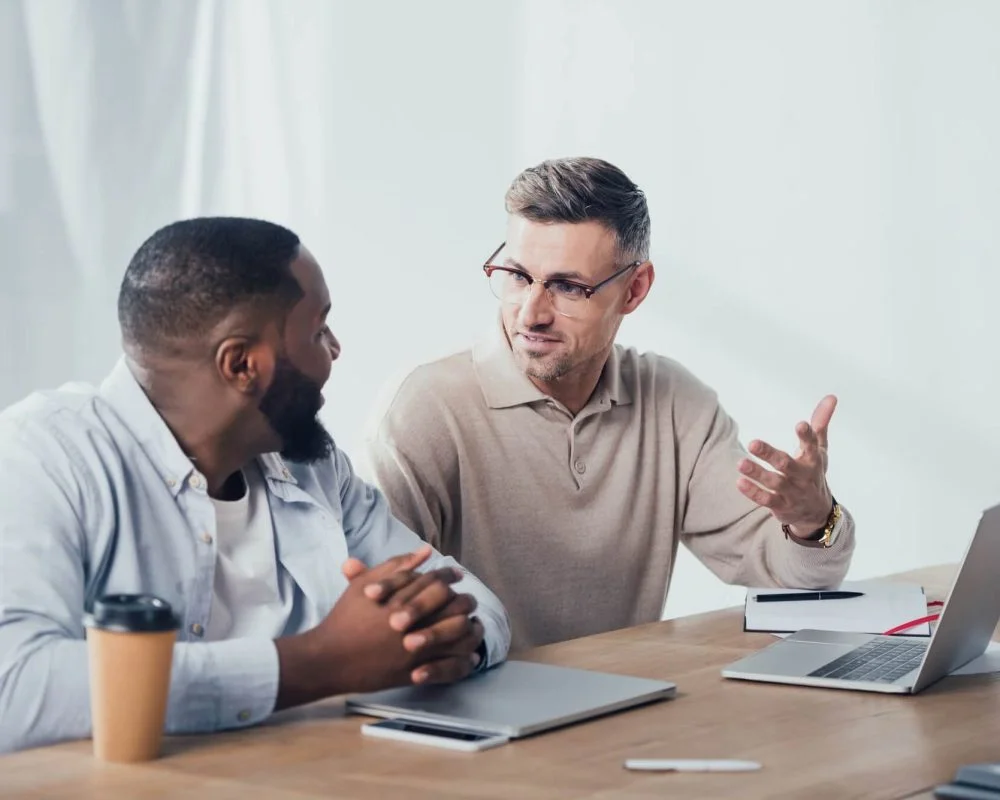 Smiling colleagues talking at a meeting table